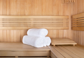 Traditional wooden sauna for relaxation with set of clean towels