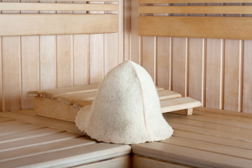 Traditional wooden sauna for relaxation with felt hat