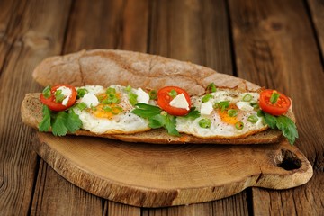 Rye bread egg bruscetta with tomatoes, cheese and greens