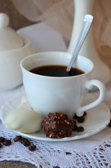 A cup of coffee, candy and branch orchid.