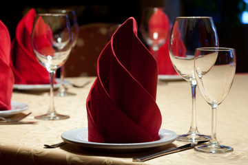 Table in a restaurant with tablecloth, napkins, wine glasses