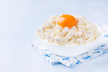 Cottage cheese with egg yolk in white bowl