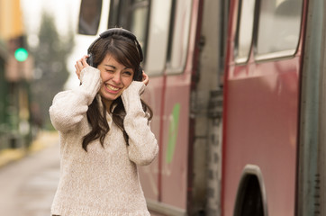 woman walking on the city street covering her ears concept of