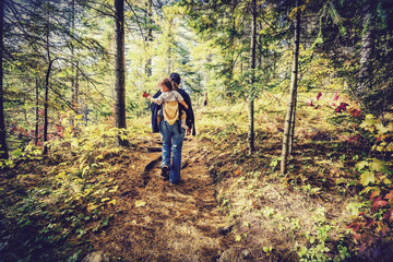 Fototapeta na wymiar Mother Hiking with Baby in a Forest - Retro Filtered