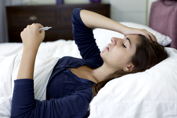 Woman in bed feeling strong headache with flu