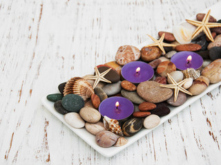 candles with sea pebbles, starfish and sea shells