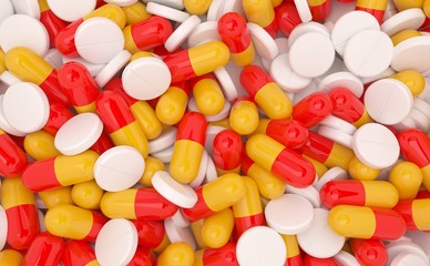 Assorted type of pills in shades of white, yellow and red.
