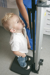 A young boy get measure in the hospital pediatrician