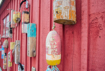 Old wood and foam lobster fishing floats on an old building
