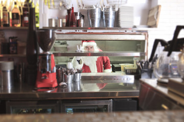 A Santa claus smiling in undustrial kitchen