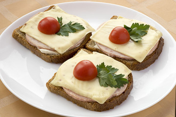 Three sandwich with grey bread,ham and cheese