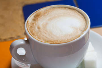 Cappuccino in a white cup. Closeup. Cup of coffee with milk.