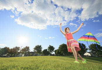 Fototapeta na wymiar A Little girl running in park with a kite