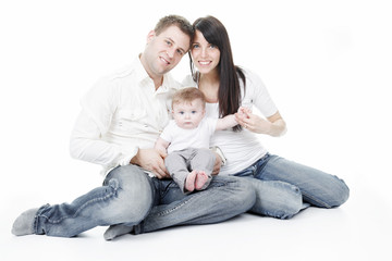 Happy family, father, mother and infant in front of a white bac