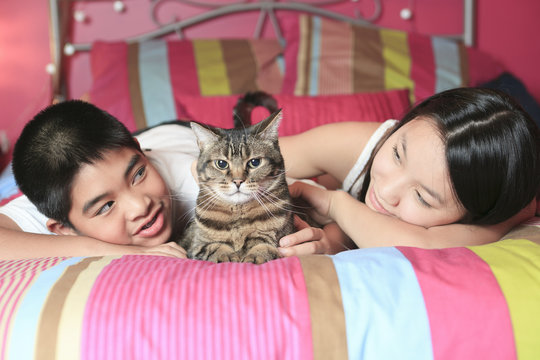 Asian Kid Lay On His Bedroom With Cat