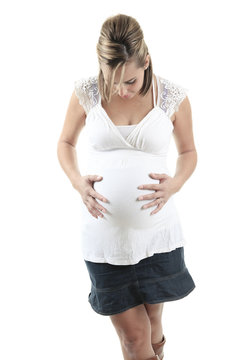 Young pregnant woman against white background