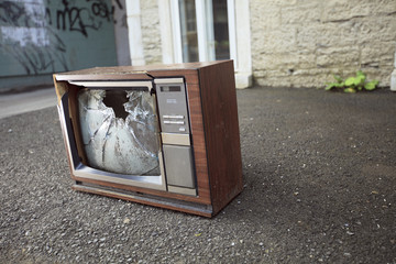 An old broken TV left on the street.