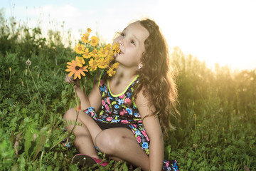 A little girl in sunset with flower