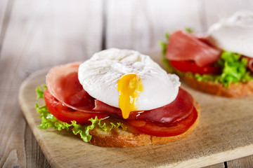 sandwich with prosciutto and poached egg tomato