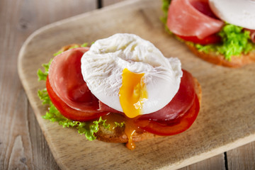 sandwich with prosciutto and poached egg tomato