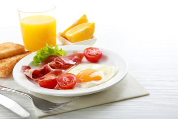 Bacon and eggs on color wooden table background