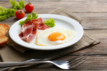 Bacon and eggs on rustic wooden planks background