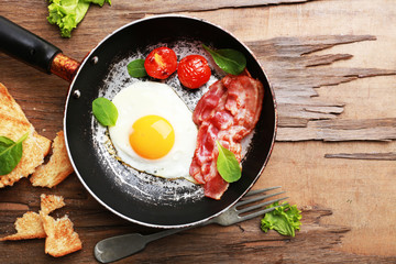 Bacon and eggs on rustic wooden planks background