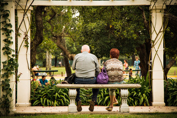 Älteres Paar sitzt im Park auf einer Bank
