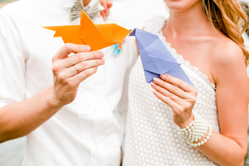 Couple holding paper origami birds © curlymary