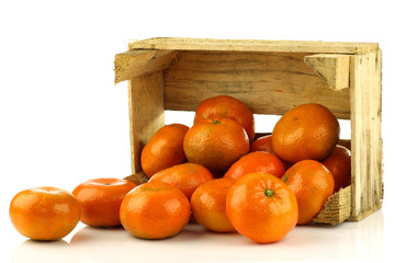 bunch of fresh tangerines in a wooden box on a white background