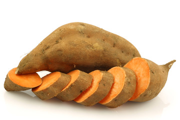 one whole sweet potato and a cut one on a white background