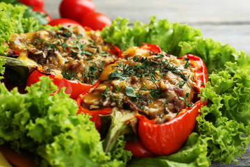 Stuffed red peppers with greens and vegetables on table close