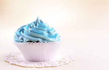 Delicious cupcake on beige background
