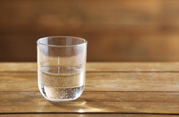 Glass of clean mineral water on rustic wooden background