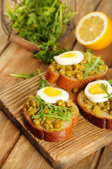 Sandwiches with green peas paste and boiled egg with herbs and