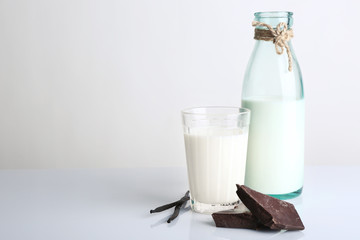 Glass and bottle of milk with chocolate chunks and vanilla