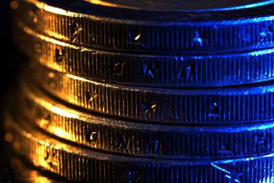 Heap of coins on wooden table, macro view
