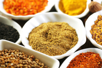 Different kinds of spices in ceramics spoons, close-up,