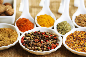Different kinds of spices in ceramics spoons, close-up,
