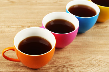 Cups of coffee on wooden table background