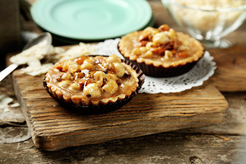 Mini cakes with nuts on wooden background