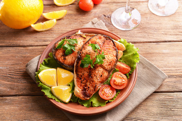 Tasty baked fish on plate on table close-up