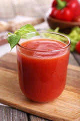 Glass of tomato juice with vegetables on wooden table close up
