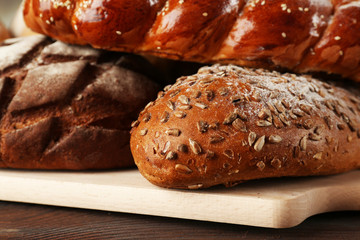 Fresh breads with bun on wooden table close up