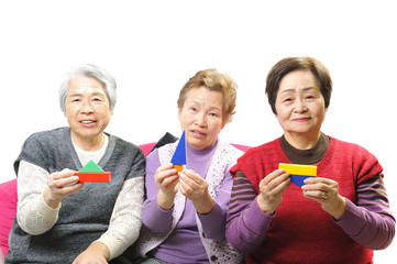 積み木を持って遊んでいる3人の高齢者の女性