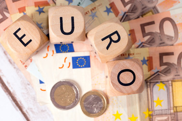 Geldscheine und Holzwürfel mit dem Wort Euro