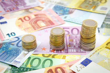 Increasing stacks of euro coins on euro banknotes