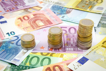Increasing stacks of euro coins on euro banknotes