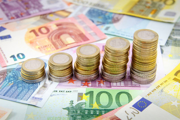 Increasing stacks of euro coins on euro banknotes