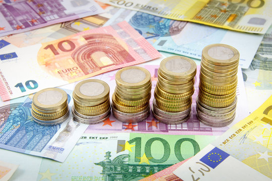 Increasing stacks of euro coins on euro banknotes